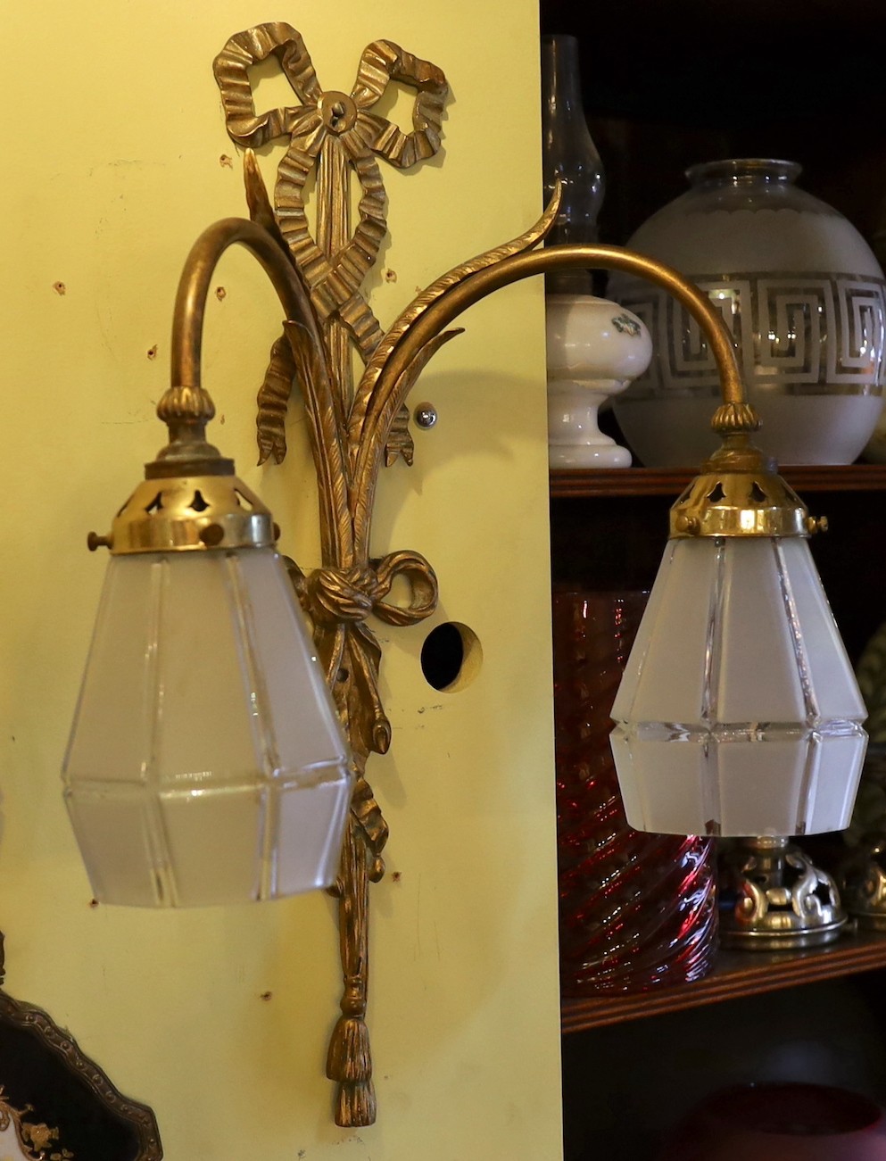 A set of three early 20th century English gilt metal twin branch wall lights with frosted glass shades, height 51cm. width 36cm